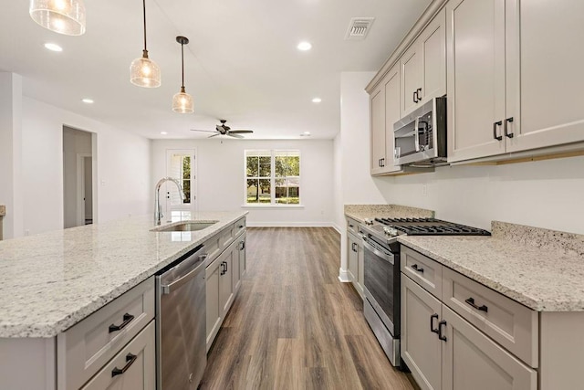 1128 W 19th Ave, Covington, LA 70433 - kitchen with appliances with stainless steel finishes, a sink, wood finished floors, a ceiling fan, and recessed lighting