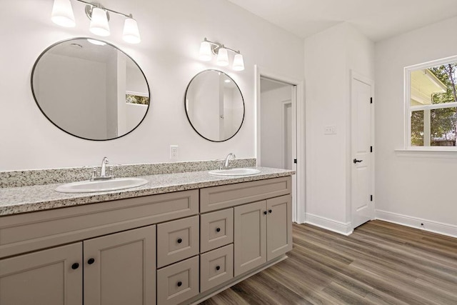1128 W 19th Ave, Covington, LA 70433 - full bath with wood finished floors, double vanity, and baseboards