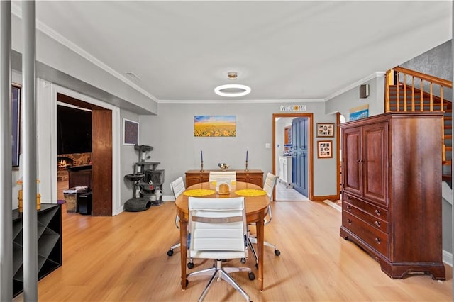 800 Marguerite Rd, Metairie, LA 70003 - dining area featuring light wood finished floors, crown molding, baseboards, and a fireplace