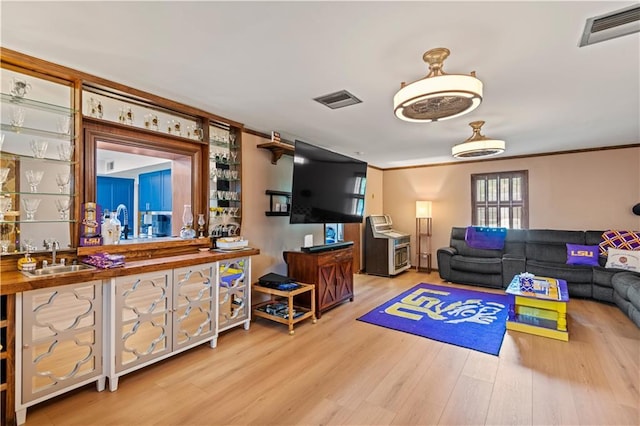 800 Marguerite Rd, Metairie, LA 70003 - living room with light wood finished floors, wet bar, and ornamental molding