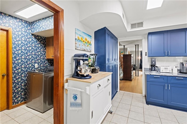 800 Marguerite Rd, Metairie, LA 70003 - kitchen with blue cabinets, light countertops, washer / clothes dryer, and wallpapered walls