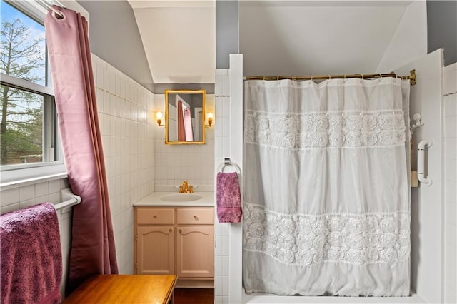 800 Marguerite Rd, Metairie, LA 70003 - bathroom featuring tile walls, vanity, lofted ceiling, and curtained shower