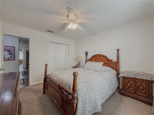 bedroom featuring ceiling fan, carpet, a textured ceiling, a closet, and visible vents