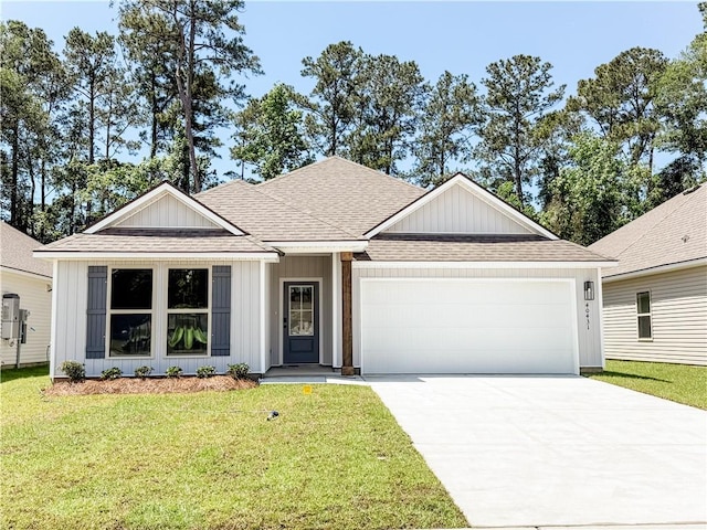 40431 Cara Mae St, Slidell, LA 70461 - view of front facade featuring a shingled roof, a garage, a front yard, driveway, and board and batten siding