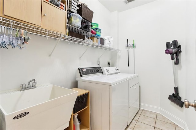 2424 Cours Carson St, Mandeville, LA 70448 - laundry room featuring washer and clothes dryer, light tile patterned floors, and baseboards