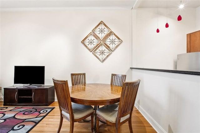 330 Julia St Unit 223, New Orleans, LA 70130 - dining room featuring light wood-style flooring and crown molding