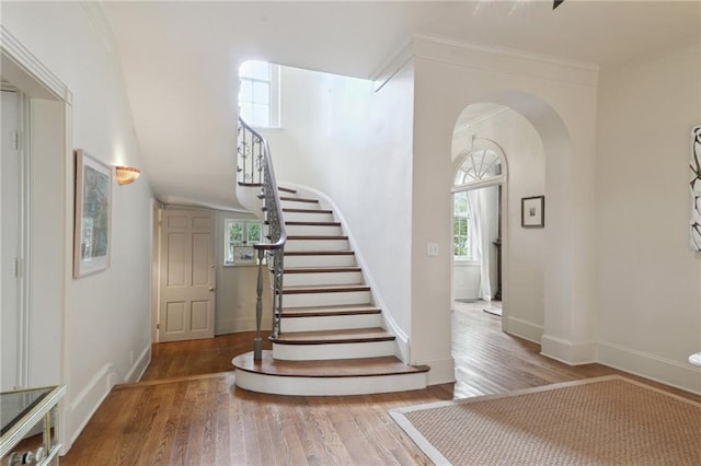 4008 Vendome Pl, New Orleans, LA 70125 - stairway featuring arched walkways, wood finished floors, baseboards, and ornamental molding