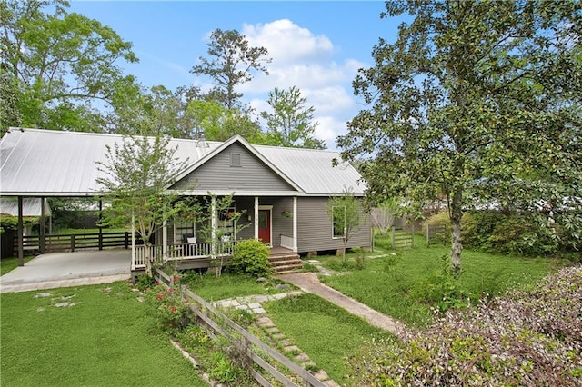 view of front facade featuring covered porch, fence, metal roof, and a front yard