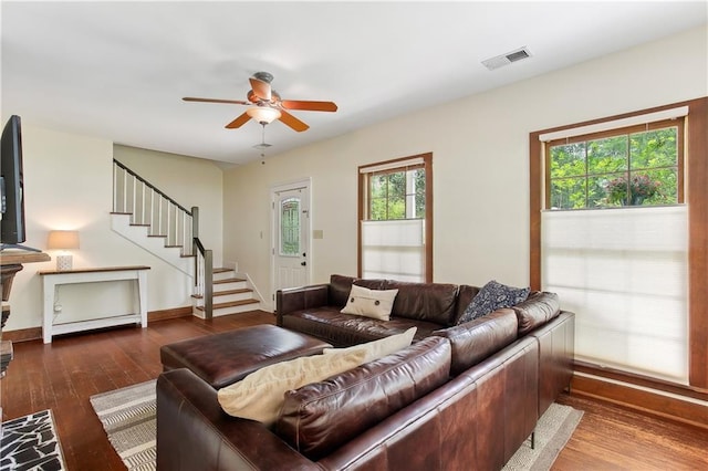 living area with visible vents, a ceiling fan, wood-type flooring, and stairway