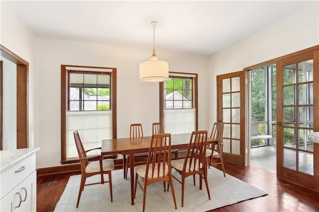 dining space with french doors, baseboards, and dark wood-style floors