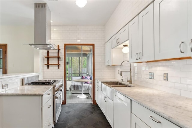 kitchen with high end stainless steel range, island range hood, white cabinetry, a sink, and dishwasher