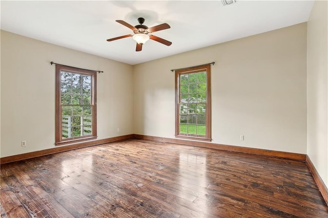 empty room with wood-type flooring, ceiling fan, and a wealth of natural light