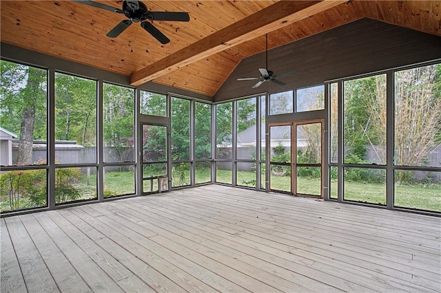 unfurnished sunroom featuring a ceiling fan and beamed ceiling