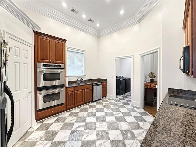 kitchen with dark stone counters, stainless steel appliances, visible vents, and washer and clothes dryer