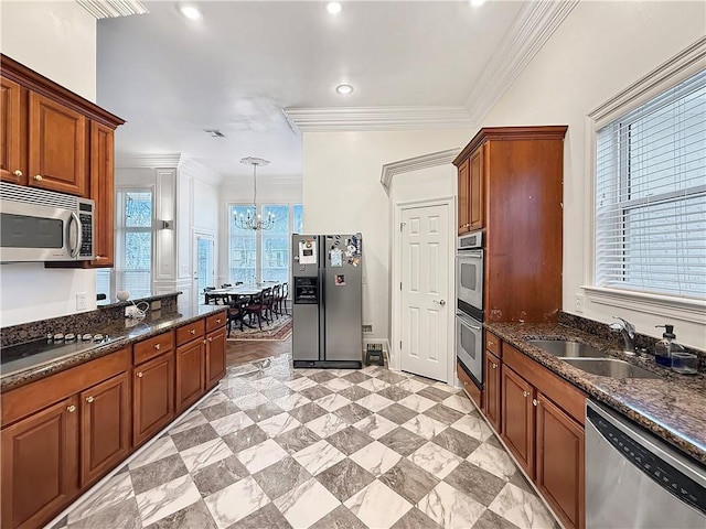 kitchen featuring crown molding, a sink, a notable chandelier, and stainless steel appliances