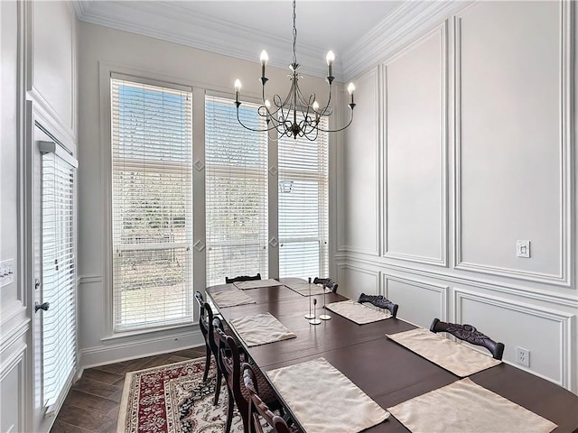 dining room featuring an inviting chandelier, ornamental molding, a decorative wall, and a healthy amount of sunlight