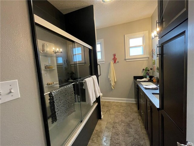 820 Solomon Pl, New Orleans, LA 70119 - bathroom featuring double vanity, a textured ceiling, and baseboards