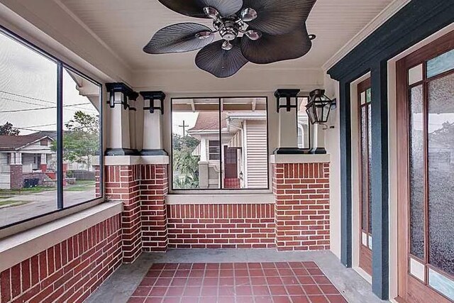 820 Solomon Pl, New Orleans, LA 70119 - unfurnished sunroom with healthy amount of natural light, concrete floors, a ceiling fan, ornamental molding, and brick wall