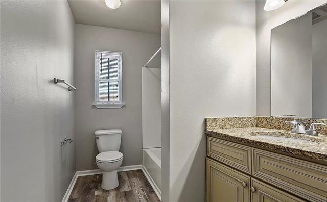 full bathroom featuring toilet, wood finished floors, vanity, and baseboards