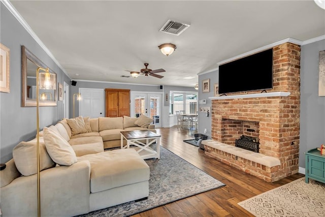 621 Gordon Ave, Harahan, LA 70123 - living room featuring crown molding, ceiling fan, wood-type flooring, a brick fireplace, and visible vents
