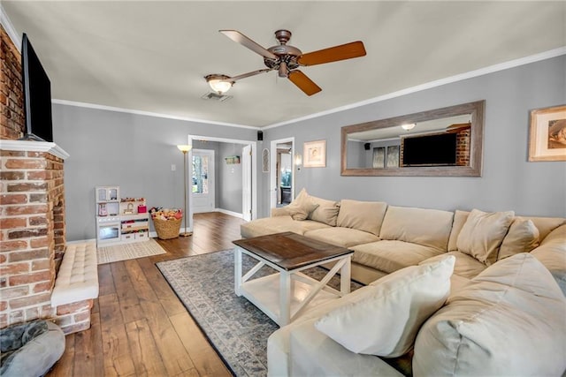 621 Gordon Ave, Harahan, LA 70123 - living room featuring visible vents, a ceiling fan, wood-type flooring, crown molding, and a brick fireplace