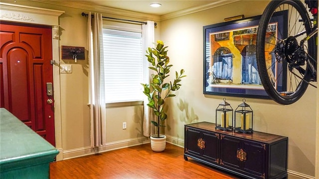 interior space featuring crown molding, wood finished floors, and baseboards