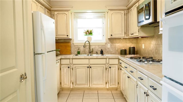 kitchen with tile countertops, white appliances, tasteful backsplash, light tile patterned flooring, and a sink