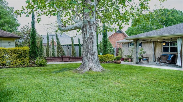 view of yard featuring ceiling fan, fence, and a patio