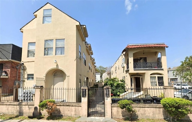 212327 Carondelet St, New Orleans, LA 70130 - view of front of home featuring a gate, a fenced front yard, stucco siding, and a balcony