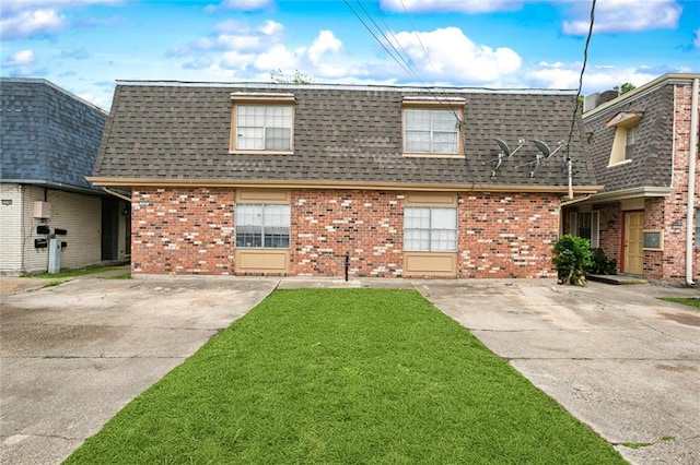 2205 Giuffrias Ave, Metairie, LA 70001 - view of front of home with brick siding, a front yard, mansard roof, and roof with shingles