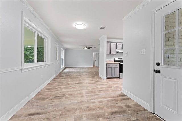 hallway with visible vents, crown molding, baseboards, and light wood finished floors