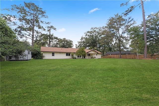 view of yard with fence and an outdoor structure