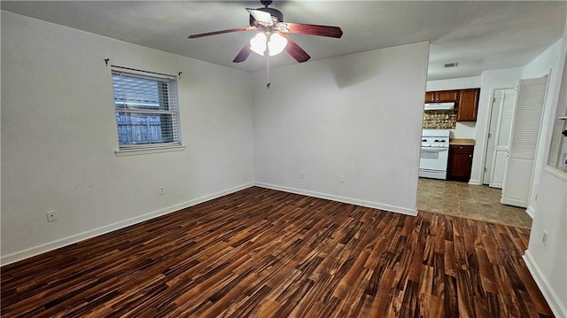 unfurnished room with baseboards, a ceiling fan, and wood finished floors