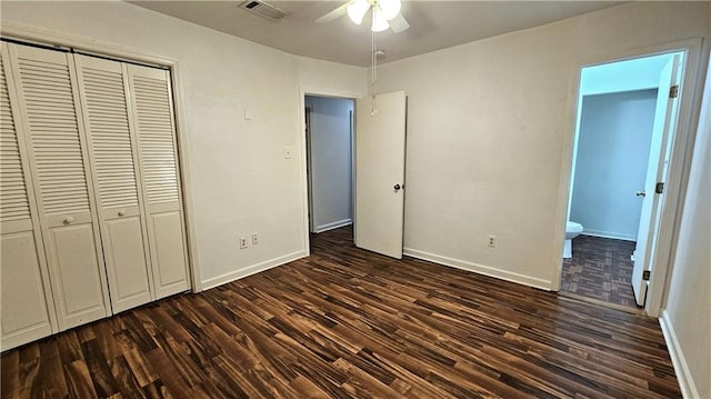 unfurnished bedroom featuring a closet, baseboards, dark wood finished floors, and visible vents