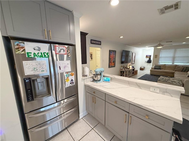 1101 Belmont Pl, Metairie, LA 70001 - kitchen featuring visible vents, stainless steel fridge, a peninsula, light stone countertops, and gray cabinets
