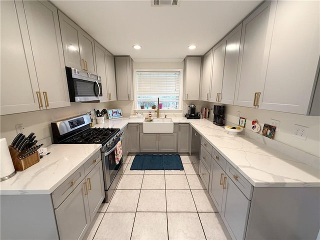 1101 Belmont Pl, Metairie, LA 70001 - kitchen with gray cabinetry, light tile patterned floors, a sink, and appliances with stainless steel finishes