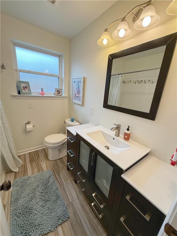 1101 Belmont Pl, Metairie, LA 70001 - full bathroom with toilet, wood finished floors, vanity, and baseboards