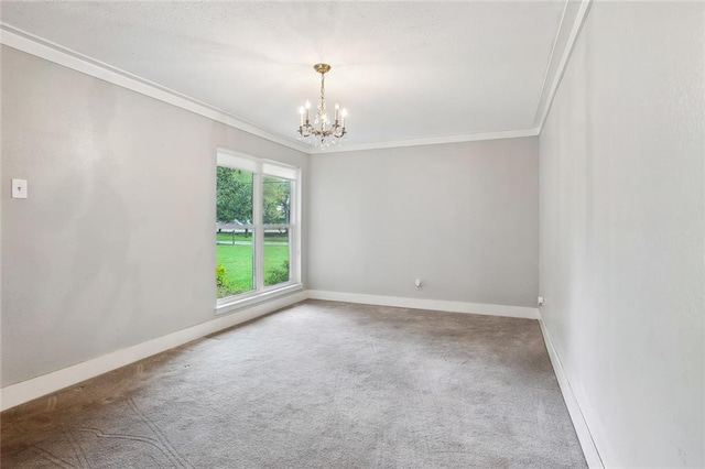carpeted spare room featuring crown molding, baseboards, and an inviting chandelier