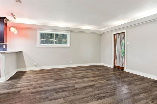 empty room featuring baseboards and wood finished floors