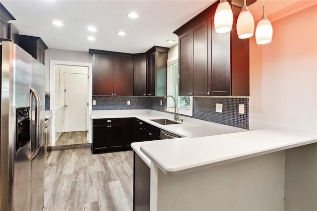 kitchen featuring tasteful backsplash, a sink, stainless steel fridge with ice dispenser, light countertops, and light wood-style flooring