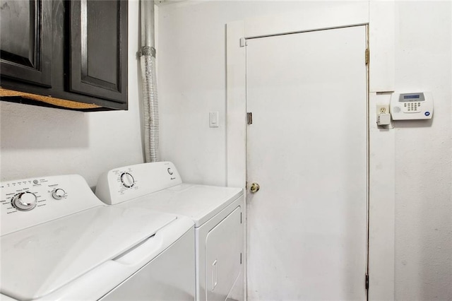 laundry room featuring separate washer and dryer and cabinet space