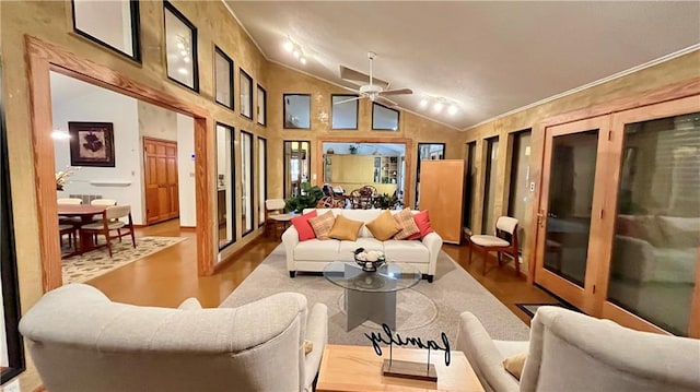 living room with ceiling fan, vaulted ceiling, and wood finished floors