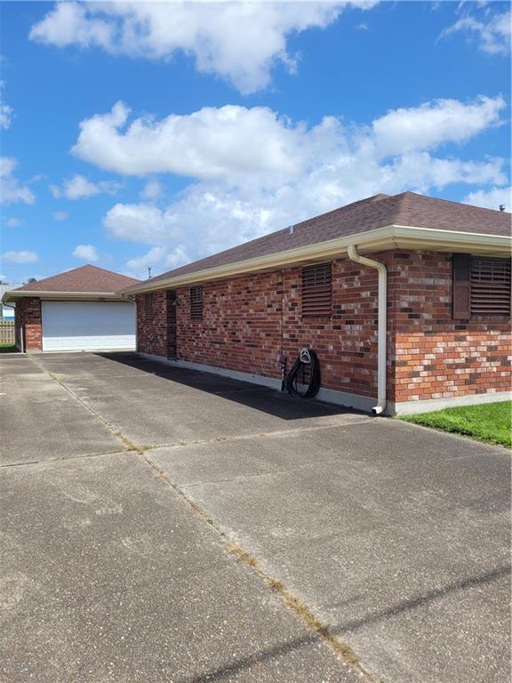 view of home's exterior with aphalt driveway, brick siding, and an attached garage