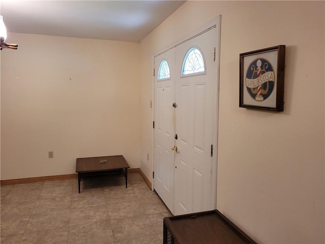 foyer entrance featuring light tile patterned floors and baseboards