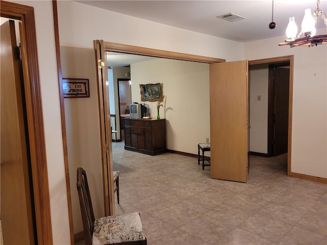 interior space featuring a chandelier, baseboards, and visible vents