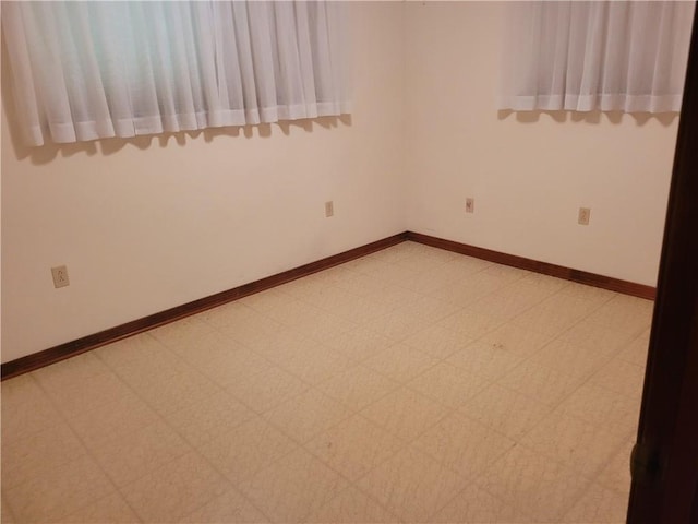 empty room with baseboards and light floors