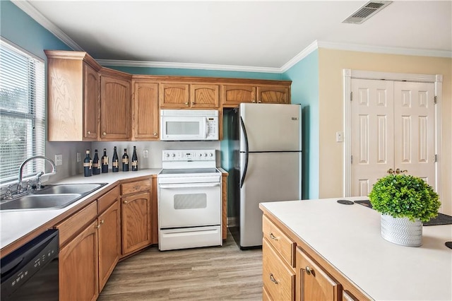32875 Rivergate Cir Unit 28, Springfield, LA 70462 - kitchen featuring white appliances, a sink, ornamental molding, light wood-style floors, and light countertops
