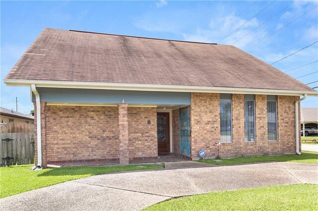 3952 Augusta St, Metairie, LA 70001 - ranch-style house with brick siding, a front lawn, roof with shingles, and fence
