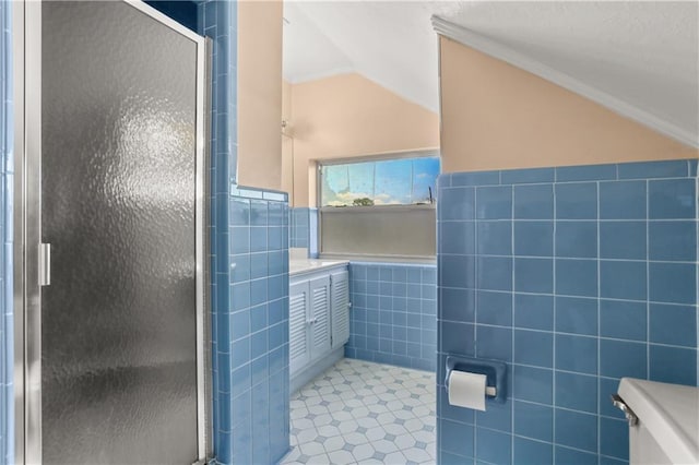 3952 Augusta St, Metairie, LA 70001 - full bath with tile patterned flooring, a wainscoted wall, tile walls, a shower stall, and lofted ceiling