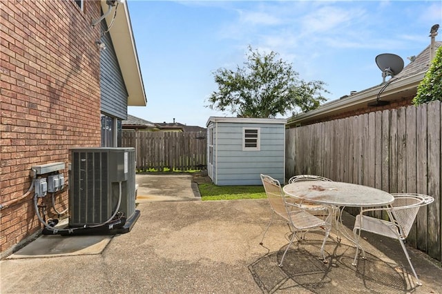 3952 Augusta St, Metairie, LA 70001 - view of patio featuring a storage shed, a fenced backyard, central AC unit, outdoor dining area, and an outdoor structure